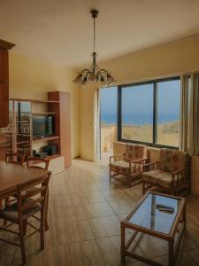 un soggiorno con sedie, tavolo e finestre di Amazing sunrise views a Il-Pergla