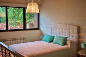 a bedroom with a bed with two blue pillows at Bonalife - Senda del Oso in Sabadia