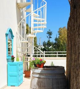 Salento Houses & Idro Suites في ناردو: برميل خشبي مع درج وورود عليه