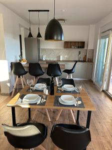 a dining room table with black chairs and a kitchen at Apartment Mila in Ugljan