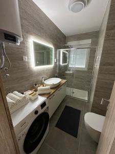 a bathroom with a sink and a washing machine at Apartment Mila in Ugljan +19 photos