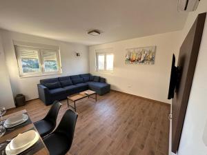 a living room with a blue couch and a table at Apartment Mila in Ugljan