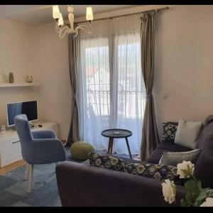 een woonkamer met een bank en een stoel bij Holiday Apartment in Budva