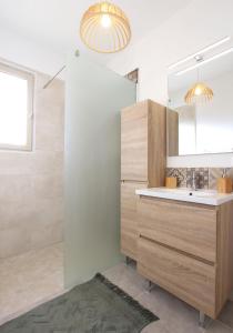 a bathroom with a sink and a mirror at La maison des cerisiers in Bédoin