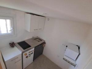 a small kitchen with a sink and a refrigerator at Un petit coin au calme in Carnoux +9 photos