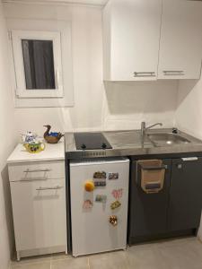 eine kleine Küche mit Spüle und Kühlschrank in der Unterkunft Un petit coin au calme in Carnoux