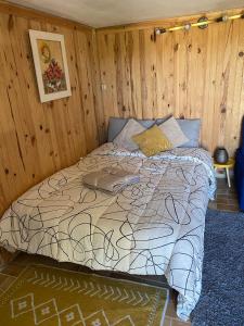 Bett in einem Zimmer mit einer Holzwand in der Unterkunft Un petit coin au calme in Carnoux