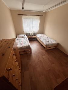 two beds in a room with a window at Rekreační dům Pod Břízou in Rudník