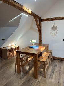 a dining room with a wooden table and benches at Chalupa pod Zubštejnem in Bystřice nad Pernštejnem