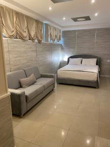 ein Schlafzimmer mit einem Bett und einem Sofa in der Unterkunft Hotel Valz in Velipojë