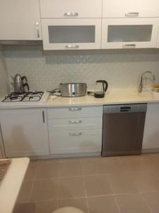 a kitchen with a sink and a stove top oven at Mavişehir Pamukkale 1+1 in Karşıyaka