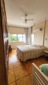 1 dormitorio con cama y ventana grande en Fantástico apartamento Frente ao mar em Balneário Camboriú en Balneário Camboriú