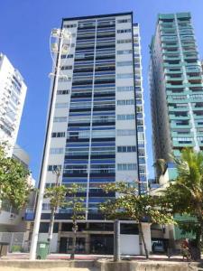 un edificio alto con árboles delante de él en Fantástico apartamento Frente ao mar em Balneário Camboriú en Balneário Camboriú