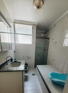 La salle de bains est pourvue d'un lavabo et d'une douche. dans l'établissement Fantástico apartamento Frente ao mar em Balneário Camboriú, à Balneário Camboriú