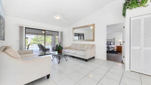 a living room with two white couches and a mirror at New house 3-room pool lake view in Port Charlotte +27 photos