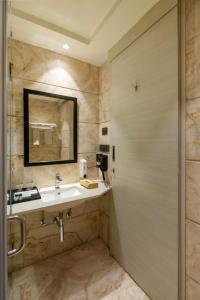 a bathroom with a sink and a mirror at Sandoz Amritsar - Lawrence Road in Amritsar