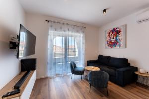 een woonkamer met een bank en een tafel bij Bernie apartments with a pool in Zadar