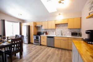 cocina con armarios de madera, mesa y comedor en 3 Bedroom Family Friendly Home, en Anchorage