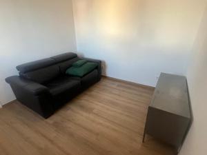 a living room with a black couch and a table at T2 Colombes proche toutes commodités #4 in Colombes