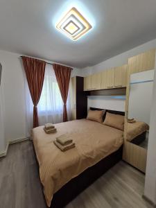 ein Schlafzimmer mit einem großen Bett mit zwei Handtüchern darauf in der Unterkunft Romanescu One Apartament in Craiova