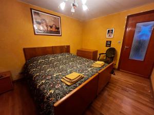 een slaapkamer met een bed, een dressoir en een deur bij Casa vacanze Le Galline in Druogno