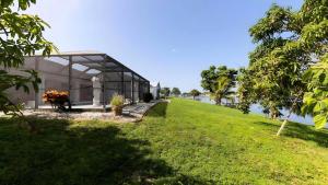 a glass house on a hill next to a body of water at New house 3-room pool lake view in Port Charlotte