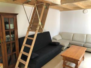 uma sala de estar com um sofá preto e uma escada de madeira em CASTILLO CARAVACA PRINCIPAL em Caravaca de la Cruz