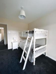 a bedroom with two bunk beds with a ladder at Highthel Holiday Home by the Northumberland Coast in Morpeth