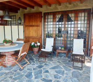 a patio with a table and chairs on a stone floor at Belvedere 10 in Pietrasanta
