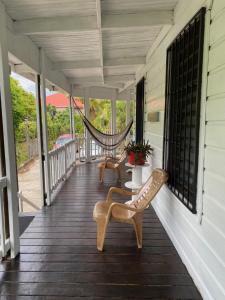 a porch with two chairs and a hammock on it at LOTO'S House in West End