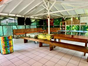 een restaurant met twee houten banken in een kamer bij Auberge K-WAN Hostel in Deshaies