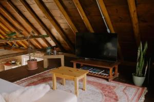 a living room with a tv and a coffee table at Chalé Deckmont in Caraa