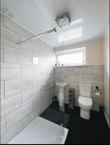 a white bathroom with a toilet and a sink at Highthel Holiday Home by the Northumberland Coast in Morpeth