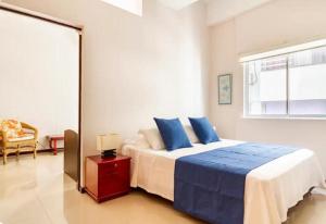 a bedroom with a large bed with blue pillows at Vista al lago en Cartagena in Cartagena de Indias