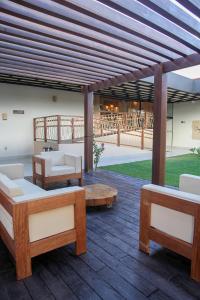 einen Pavillon mit Sofas und Tischen auf einer Holzterrasse in der Unterkunft HOTEL SERRA DA CAPIVARA RESORT E CONVENTION in São Raimundo Nonato