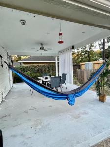 a blue hammock on a porch with a table at Peaceful Forest Shadow in Humble