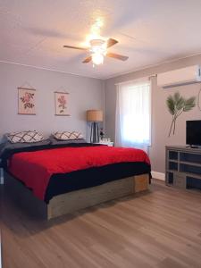 a bedroom with a large bed with a red blanket at Peaceful Forest Shadow in Humble