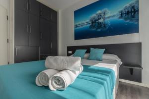 een slaapkamer met een bed met handdoeken erop bij Estudio con balcones 2ºA playa76 in Torremolinos