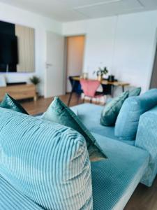 ein blaues Sofa mit Kissen im Wohnzimmer in der Unterkunft Penthouse, Sonnenbalkon, Netflix in Saarbrücken