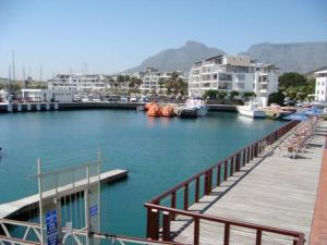 a dock with boats in a marina with buildings at 522 The Granger in Cape Town