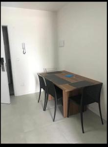 - une table en bois avec des chaises noires dans l'établissement Apartamento studio, à Maceió