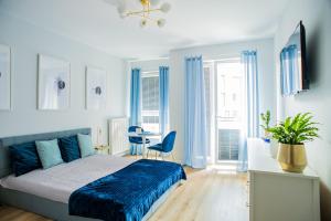 a bedroom with a bed and a desk with a chair at Flatbook - City Center Apartments Bastion Wałowa in Gdańsk