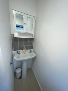 a white bathroom with a sink and a mirror at Stevenage Studios - Superior Suite in Stevenage