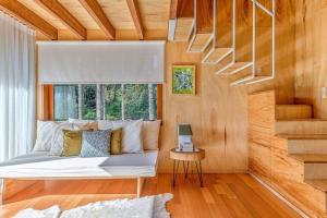 a bed in a room with a window and a stair at Casa Árbol - Pousada Nacarapina in São Francisco de Paula
