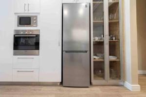 Un refrigerador de acero inoxidable en una cocina con gabinetes blancos. en 522 The Granger, en Ciudad del Cabo