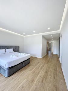 1 dormitorio blanco con 1 cama y suelo de madera en Villa Faísca, en São Roque do Faial