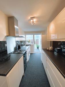 a kitchen with white cabinets and black counter tops at Highthel Holiday Home by the Northumberland Coast in Morpeth