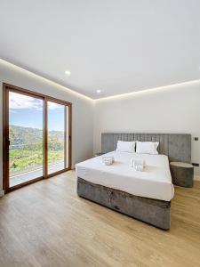 1 dormitorio con cama grande y ventana grande en Villa Faísca, en São Roque do Faial