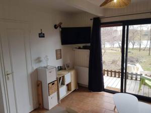 a kitchen with a refrigerator and a sliding glass door at Chaleureux Chalet Lac Roussinas in Anglès