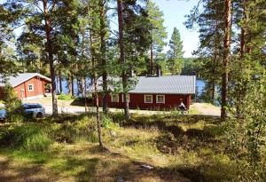 a cabin in the woods with a person on a bike at Cottages SAA in Punkaharju